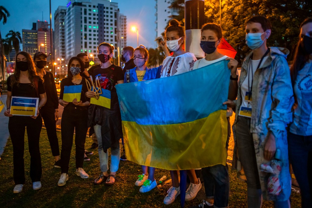 People hold a Ukraine flag during a protest against the massive military operation by Russia against Ukraine, in front of the Russian Embassy in Kuala Lumpur on February 25, 2022. - The Malaysian Insight pic by Seth Akmal.